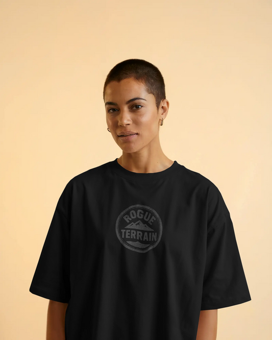A woman wearing Urban Outdoor T-Shirt – Black Rogue Terrain Oversized Tee by Qurrito
