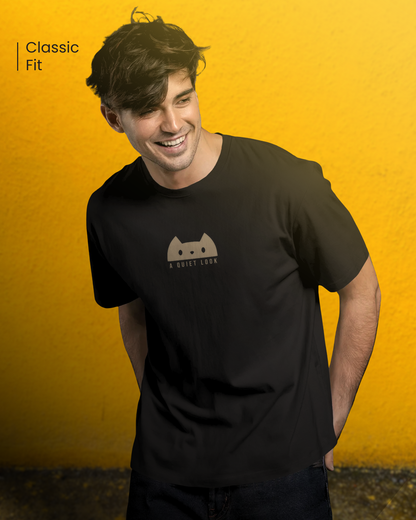 Man wearing Qurrito’s “A Quiet Look” Regular Fit Cat Lover T-Shirt in black cotton. The minimalist cat design captures a chill, relaxed, and playful mood — perfect for casual everyday wear.