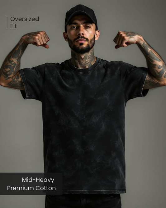 Male model showing off Qurrito’s Acid Wash Vintage Black Oversized T-Shirt made from mid-heavy premium cotton. With its washed finish and relaxed silhouette, this tee reflects mysterious, dark, confident, and bold moods — ideal for fearless streetwear style.