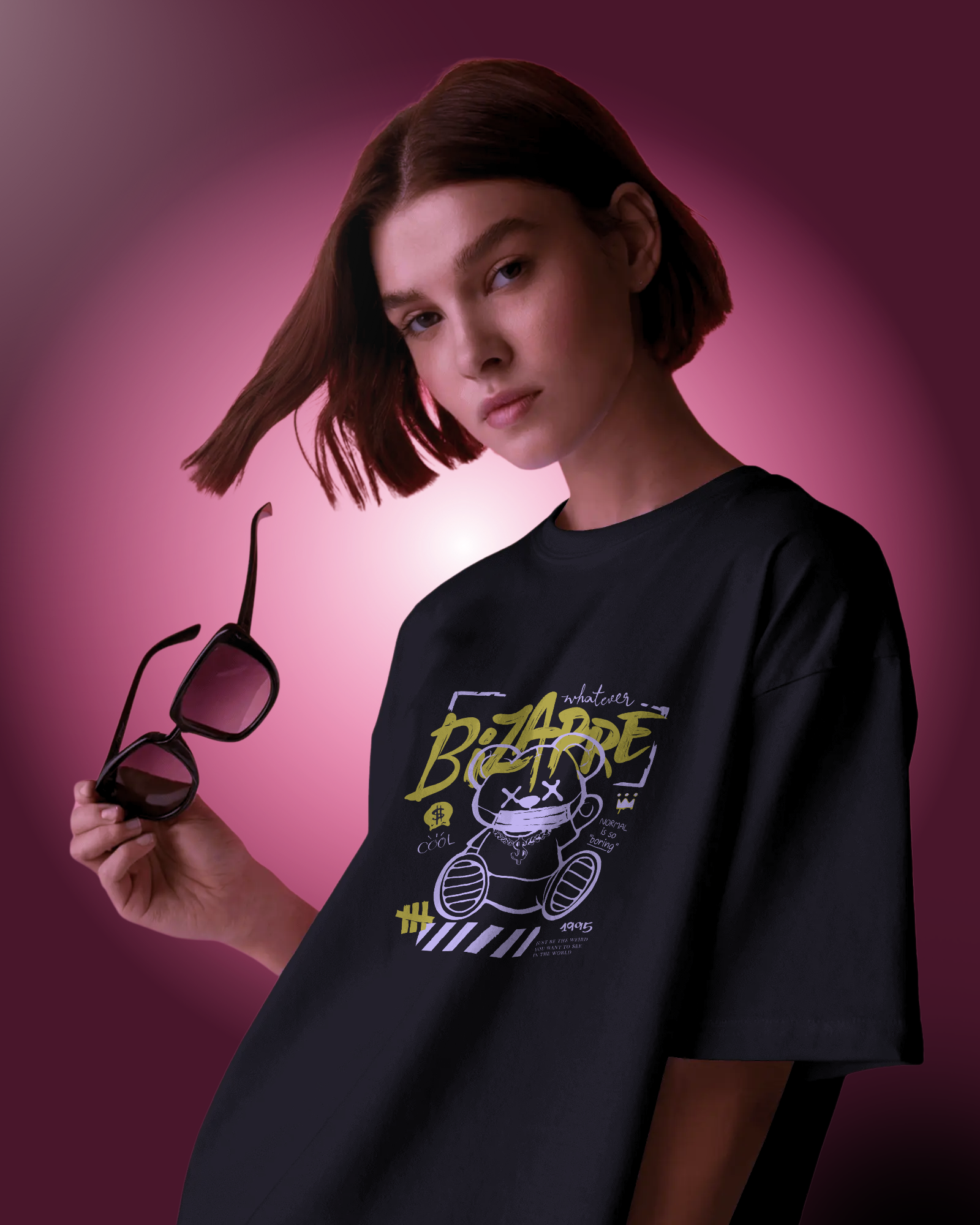 Woman wearing the mysterious and quirky "Bizarre" T-shirt. Oversized fit with a bold neon yellow graphic. Dark streetwear aesthetic by Qurrito.