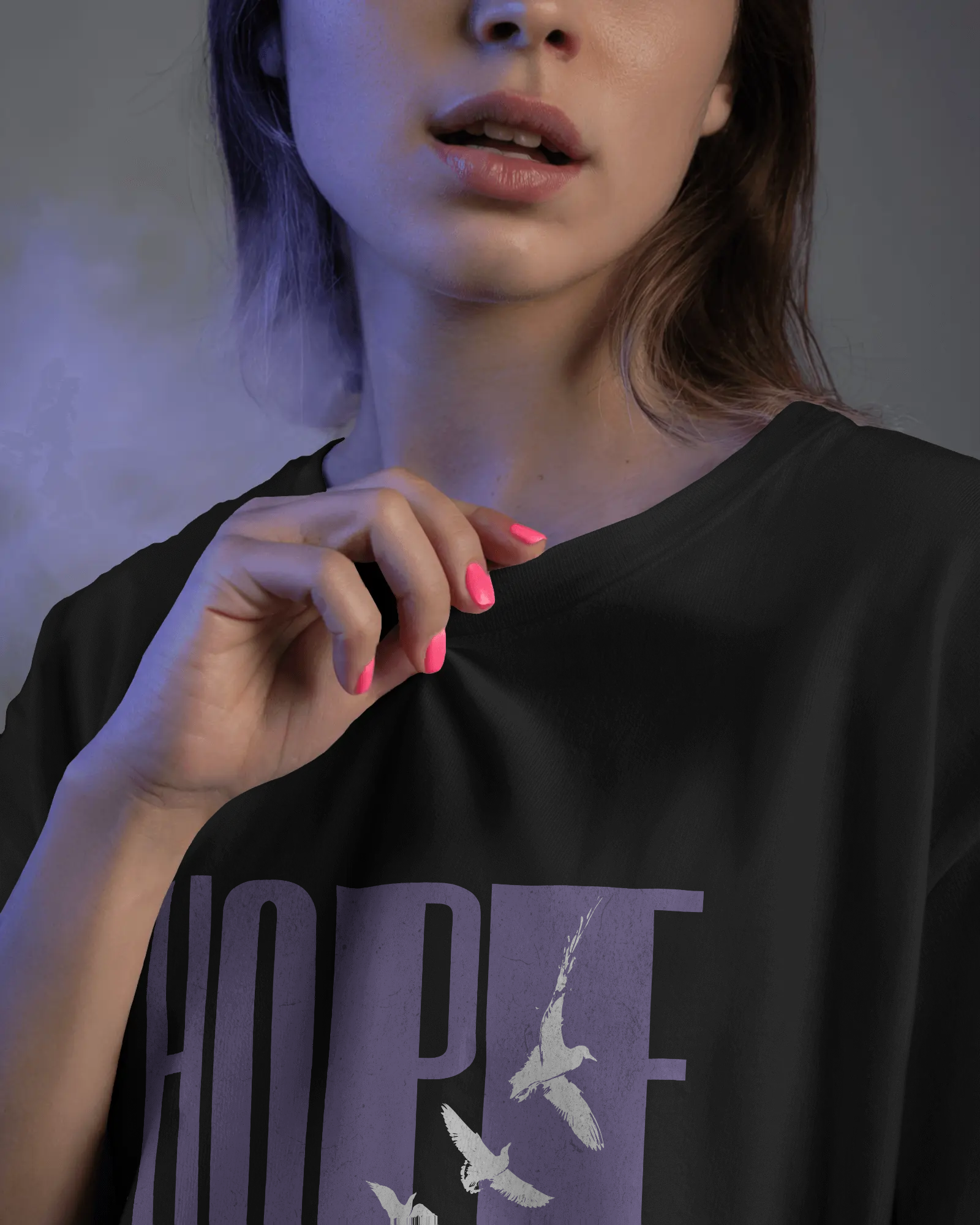Close-up of a woman wearing Qurrito’s Black Hope Oversized T-Shirt, featuring minimalist bird graphics and lavender typography. The bold yet calm design reflects confidence and focus, ideal for modern women’s oversized streetwear or casual bold looks.