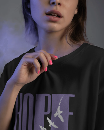 Close-up of a woman wearing Qurrito’s Black Hope Oversized T-Shirt, featuring minimalist bird graphics and lavender typography. The bold yet calm design reflects confidence and focus, ideal for modern women’s oversized streetwear or casual bold looks.