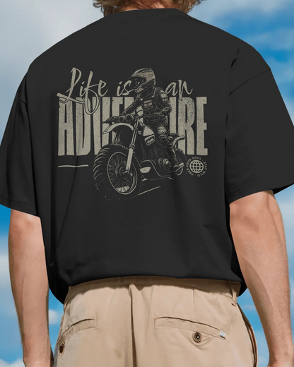 Close-up of Qurrito’s Motorbike Graphic Oversized T-Shirt highlighting the gold “Life is an Adventure” print with a motorbike. Crafted from soft premium cotton, this adventure-inspired tee captures energetic, pumped, confident, and bold moods — blending streetwear edge with travel spirit.