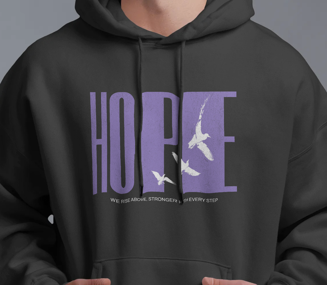 close up of model wearing Qurrito’s Black Streetwear Hoodie – Hope Unisex Oversized Hoodie made from premium heavy fabric, featuring “HOPE” graphic with white birds in purple print, showcasing relaxed oversized fit.