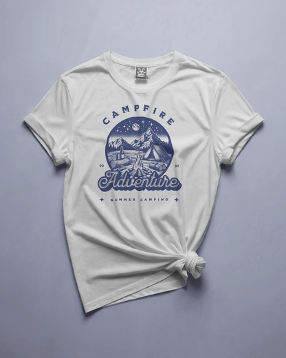 White Campfire Adventure Regular Fit T-Shirt by Qurrito displayed in a flat lay, featuring blue summer camping mountain graphic print. The premium cotton tee embodies romantic, affectionate, chill, relaxed, happy, and cheerful moods — perfect for wanderers and outdoor lovers.