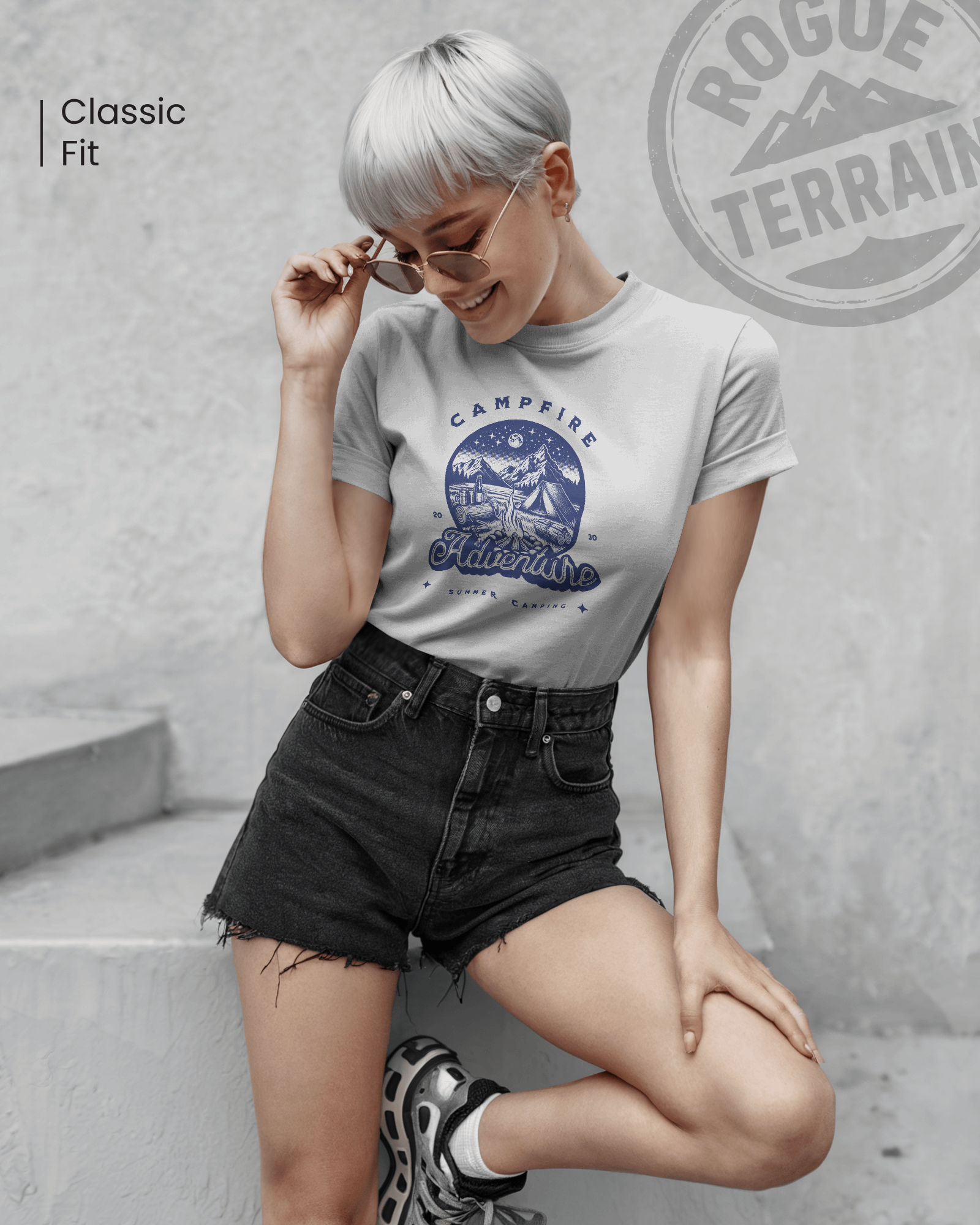 Female model styled in Qurrito’s Campfire Adventure Regular Fit T-Shirt, featuring a summer camping blue print design. Made from soft cotton, this tee radiates romantic, affectionate, chill, relaxed, happy, and cheerful moods — ideal for laid-back, adventurous streetwear vibes.