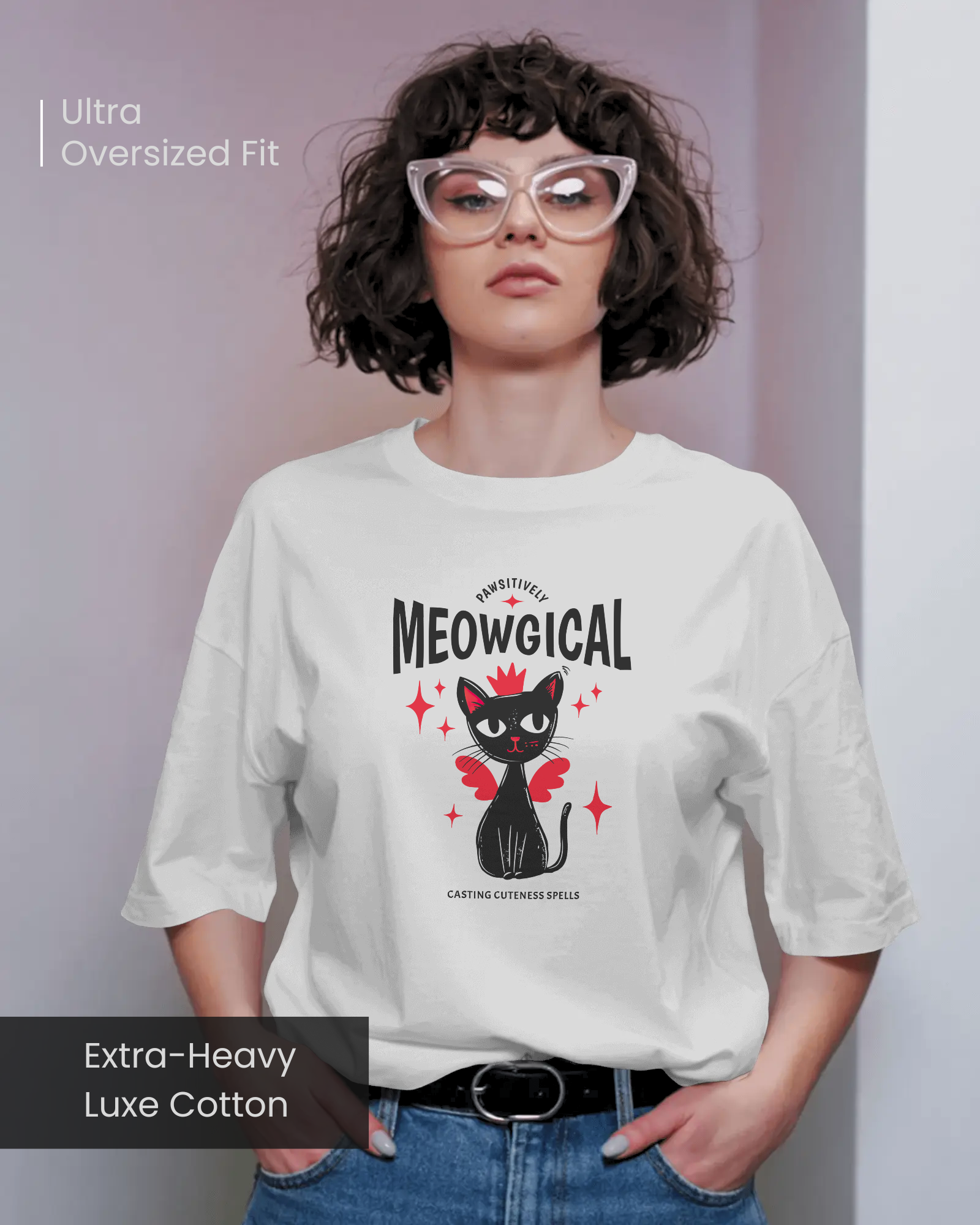 Female model wearing Qurrito’s Meowgical Magic Cat Wings Oversized T-Shirt in white, featuring a cute black cat with red wings and stars graphic, made from extra-heavy luxe cotton in an ultra-oversized fit.