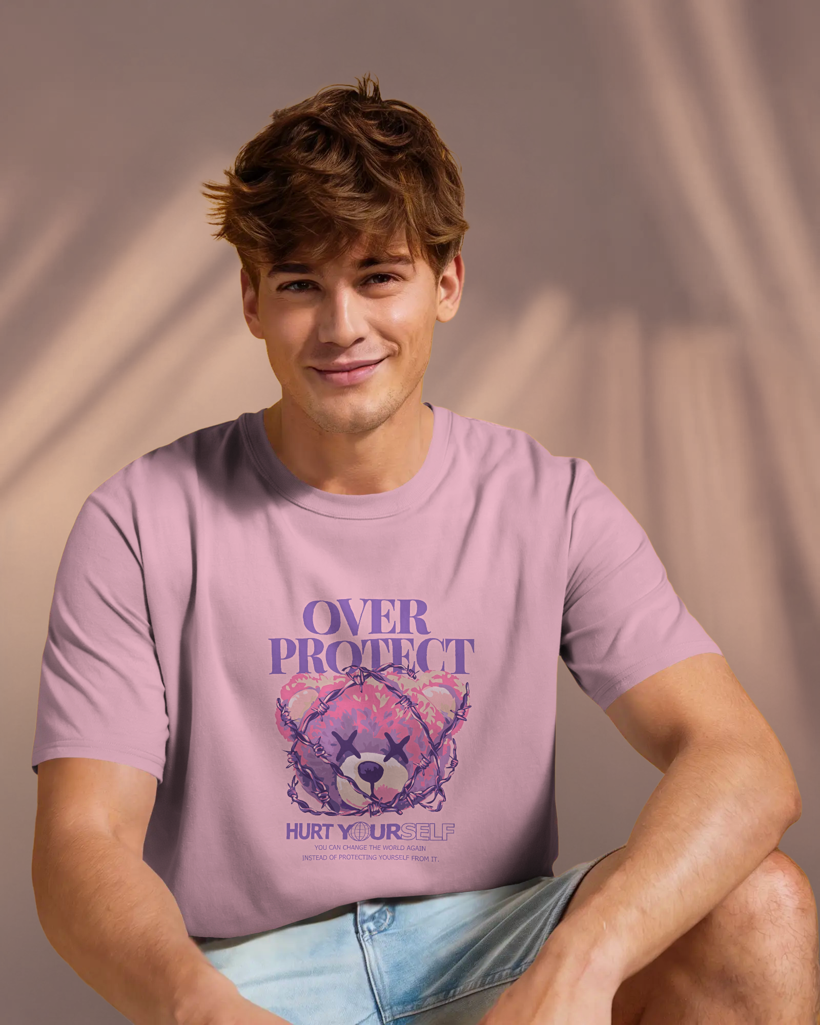Man wearing Qurrito’s Edgy Pink T-Shirt – Barbed Bear Edition. The playful yet dark teddy bear graphic wrapped in barbed wire reflects a confident, quirky, and bold streetwear mood.