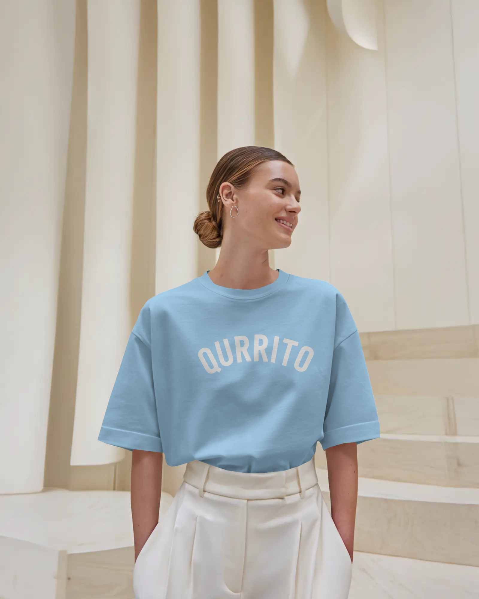 Branded oversized t-shirt for men and women in sky blue with Qurrito arch logo, styled for casual streetwear vibes.