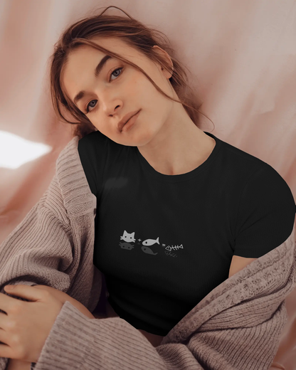 Woman in cozy setting wearing Qurrito’s Minimalist Cat & Fish Equation T-Shirt in black cotton layered with Lilac sweater This playful, quirky regular-fit tee perfectly captures fun streetwear energy with a lighthearted cat design.