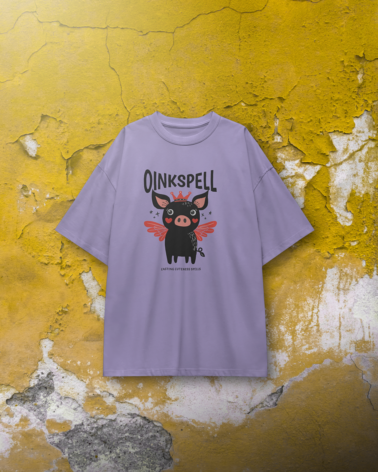 Lavender Oinkspell Oversized T-Shirt for Women by Qurrito hanging against a rustic yellow wall. This quirky graphic tee brings a fun, cheerful vibe for women looking for playful streetwear or pastel casual wear.
