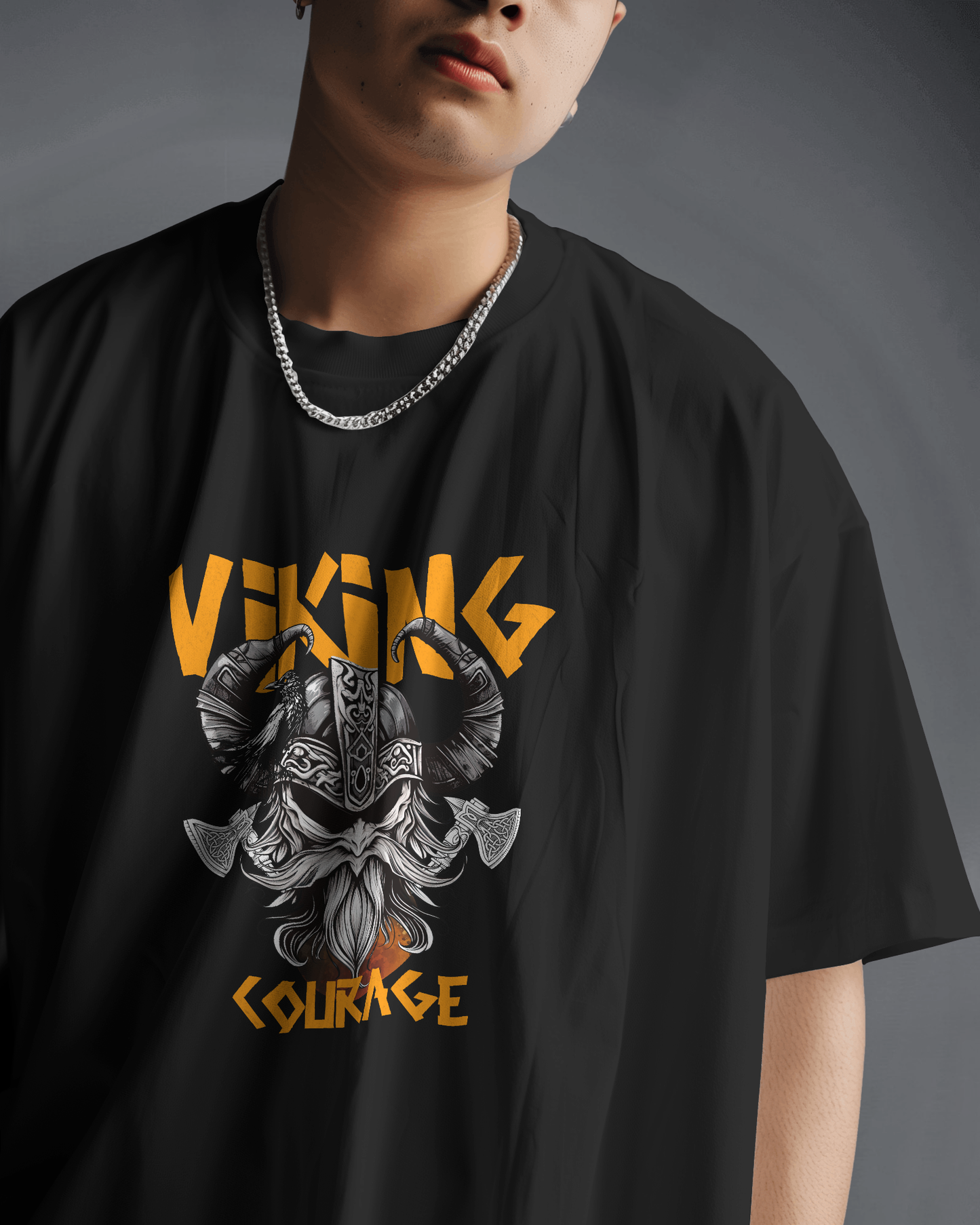 Close-up of a man wearing Qurrito’s Oversized Viking T-Shirt in black. The fierce Viking helmet and axe graphic radiates confidence and bold energy. Styled with a silver chain and minimal accessories, perfect for men’s bold streetwear or unisex oversized looks.