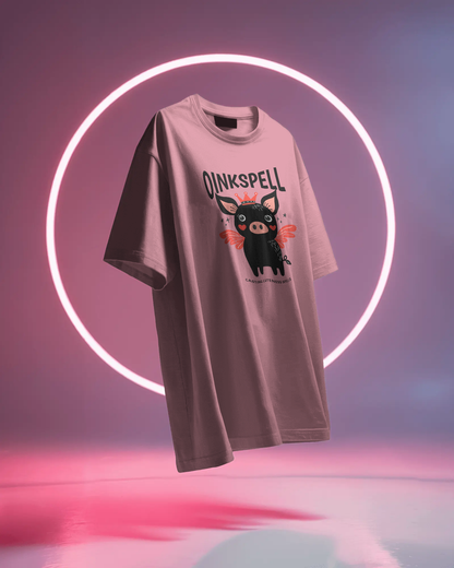 Floating Pink Oinkspell Oversized T-Shirt by Qurrito under neon lighting, giving a playful and cheerful streetwear vibe. A perfect quirky oversized cotton tee for women who love fun fashion and pastel-colored outfits.