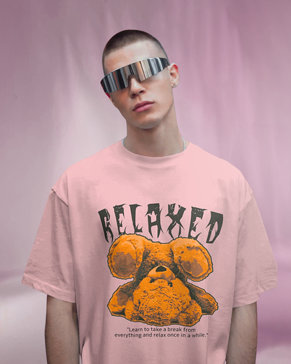 Male model wearing Qurrito’s Pink Relaxed Oversized T-Shirt featuring bold “RELAXED” typography and teddy bear print, crafted from mid-heavy premium cotton for a soft, casual streetwear look.
