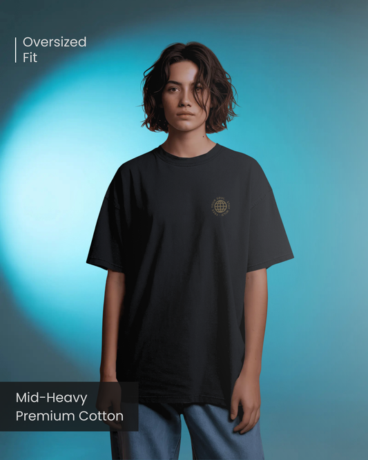 A female model wearing Qurrito’s Black Oversized Streetwear T-Shirt with “Free Your Soul” embroidered golden logo, standing confidently in front of a blue studio light background.