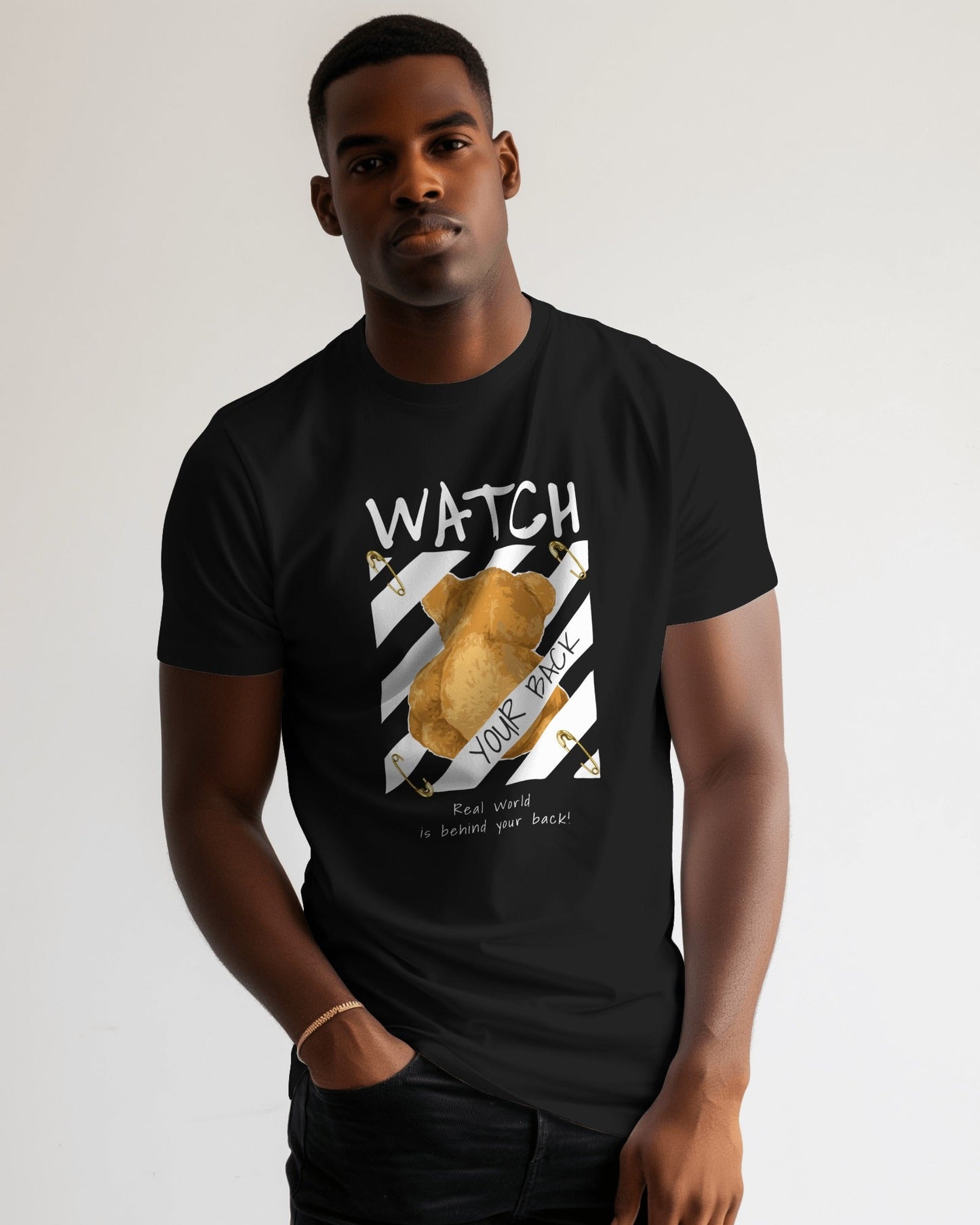 lack regular fit t-shirt featuring a back-facing teddy bear graphic with warning stripes, bold text “Watch Your Back,” and the phrase “Real world is behind your back.” Urban Graphic Wear by Qurrito.