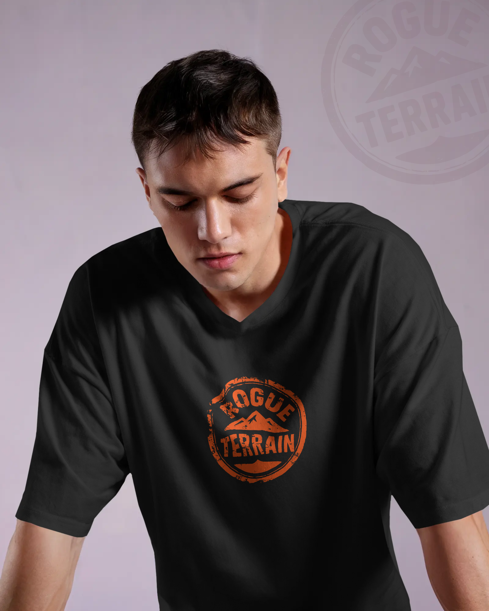 Male model wearing Qurrito’s Rugged Outdoor T-Shirt featuring the bold orange Rogue Terrain logo printed on black oversized cotton. This premium outdoor streetwear tee reflects energetic, pumped, confident, bold, serious, and focused moods — perfect for adventurous personalities and rugged fashion lovers.