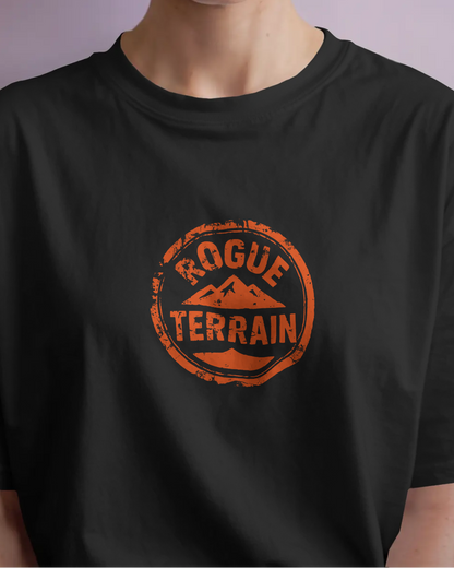 Female model styled in Qurrito’s Black Rogue Terrain Logo Oversized Tee, a rugged outdoor-inspired T-shirt made from mid-heavy premium cotton. The design embodies energetic, pumped, confident, bold, serious, and focused moods, blending outdoor aesthetics with modern urban streetwear fashion.