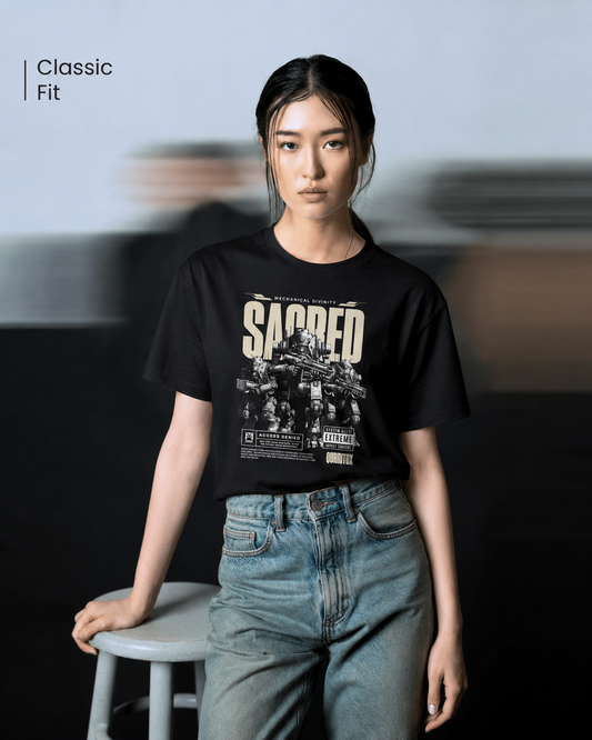 Woman standing with hands in pockets wearing QURRiTO Sacred Mecha Divinity black cyberpunk t-shirt featuring bold SACRED mecha graphic, paired with oversized light wash jeans.