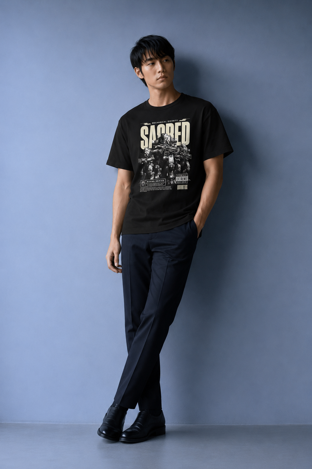 Man in QURRiTO Sacred Mecha Divinity regular fit black t-shirt with futuristic mecha graphic, full body shot showing clean streetwear styling with dark trousers.
