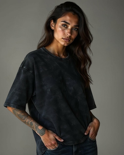 Female model wearing Qurrito’s Textured Black Oversized T-Shirt from the Acid Wash Vintage Edition. The soft mid-heavy cotton fabric and washed texture create a mysterious, dark, confident, and bold vibe — perfect for streetwear lovers with an edge.