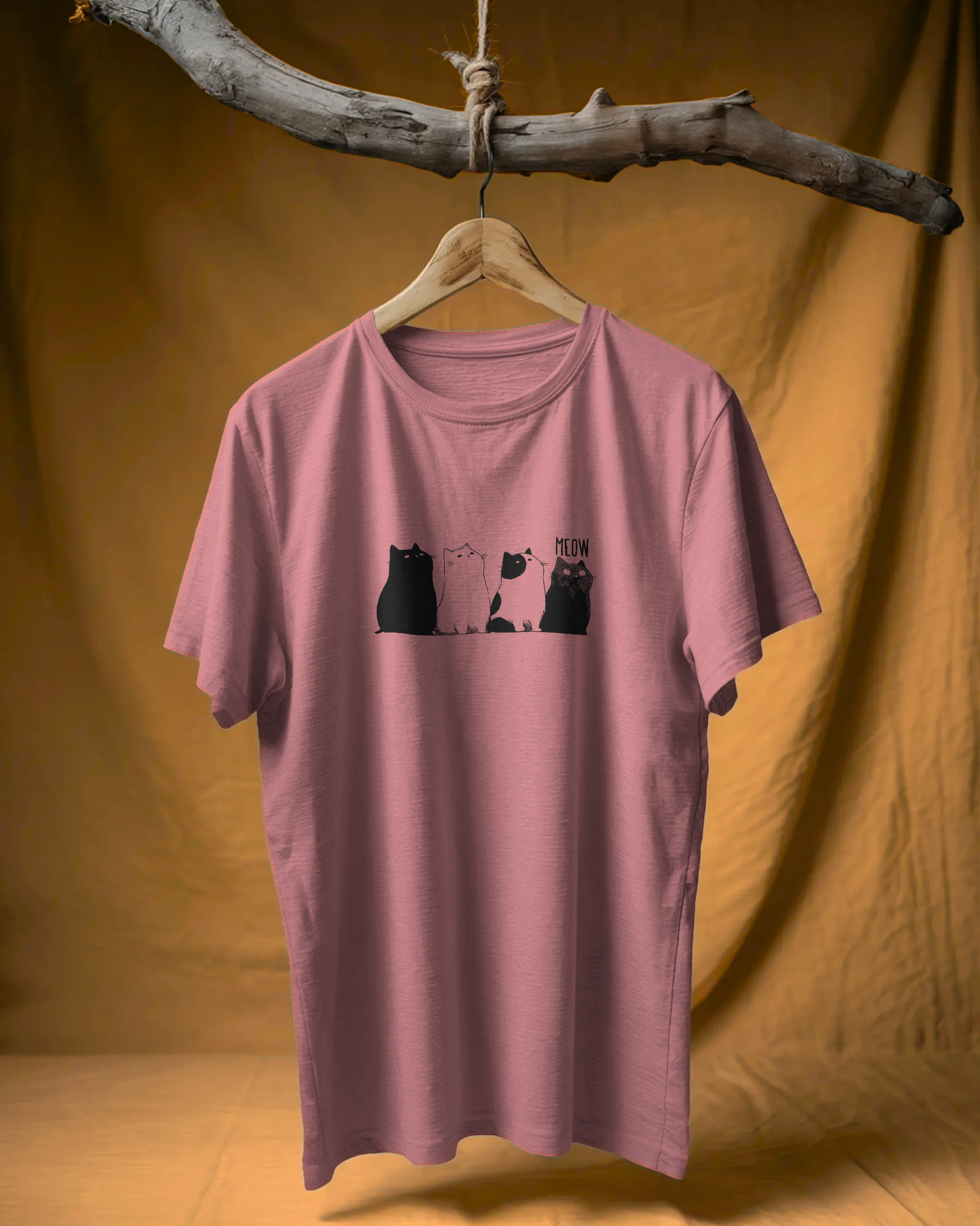 Qurrito The Purr-ple Squad graphic t-shirt in Regular Fit on a wooden branch hanger. The Mauve/Dusty Rose tee displays the Chill Cat Graphic print of three black and white cats.