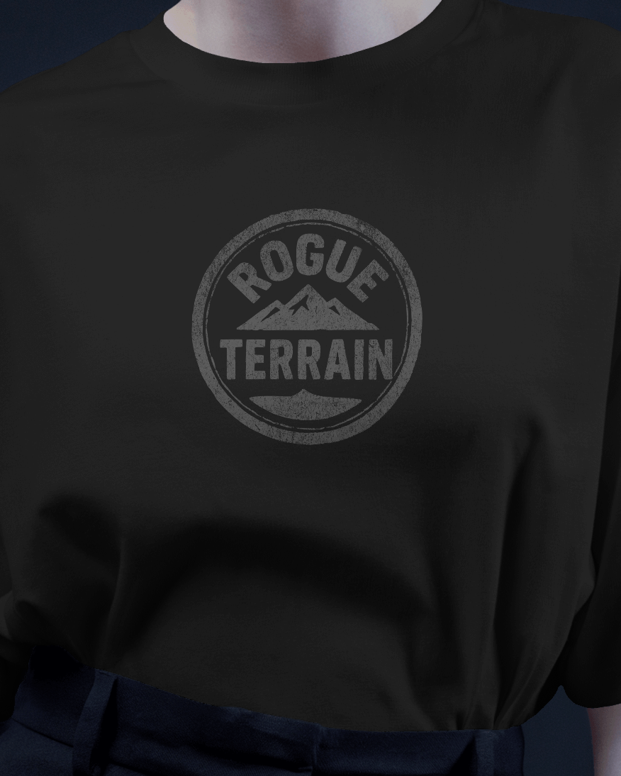 Female model wearing Qurrito’s Urban Outdoor T-Shirt in black featuring the Rogue Terrain logo printed in a subtle steel finish. This minimalistic oversized tee blends streetwear with outdoor aesthetics, reflecting chill, relaxed, serious, and focused moods for a modern urban vibe.