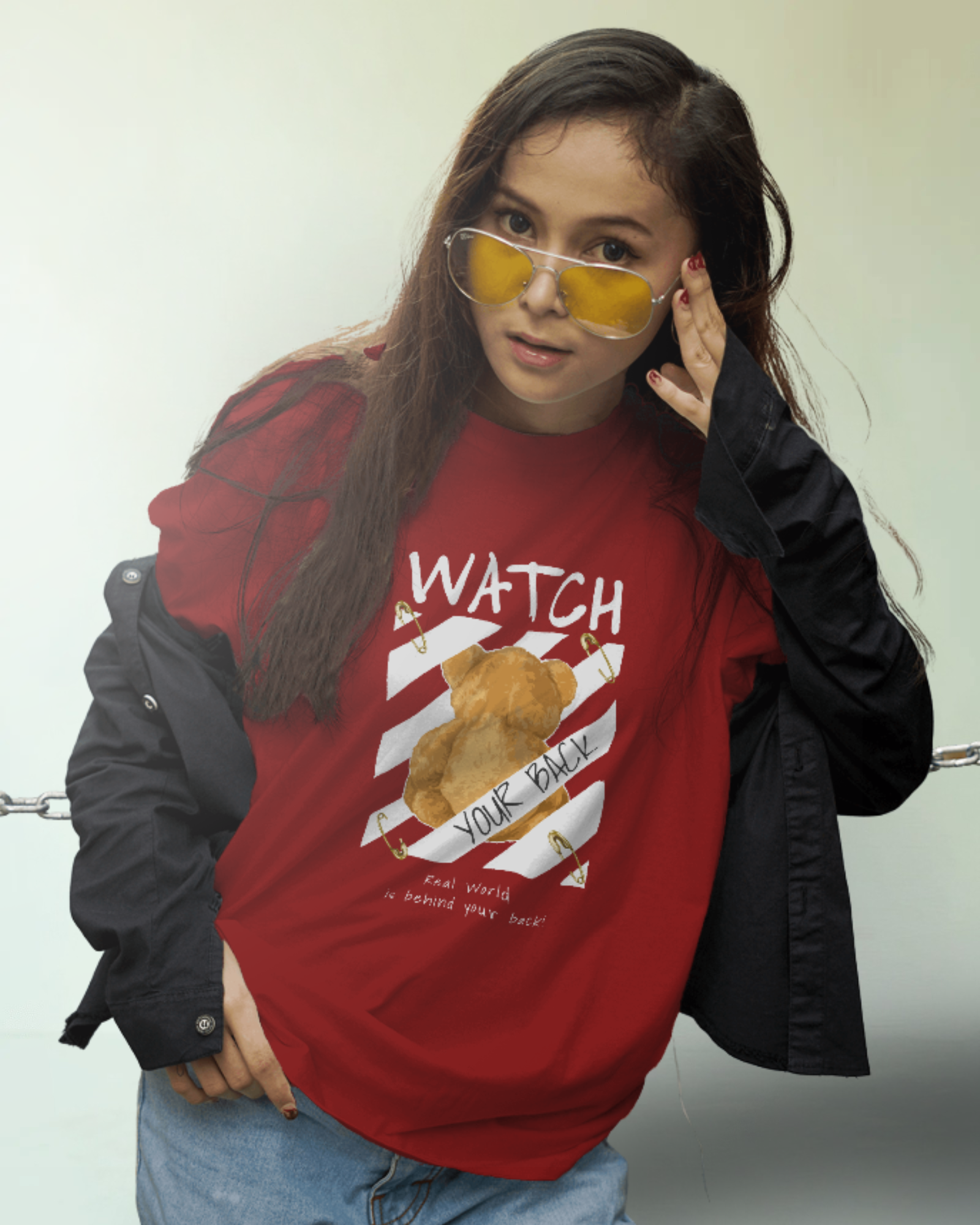 Female model wearing Qurrito’s “Watch Your Back” Red Tee featuring teddy bear graphic and diagonal stripe design, made from premium cotton in a regular urban streetwear fit.